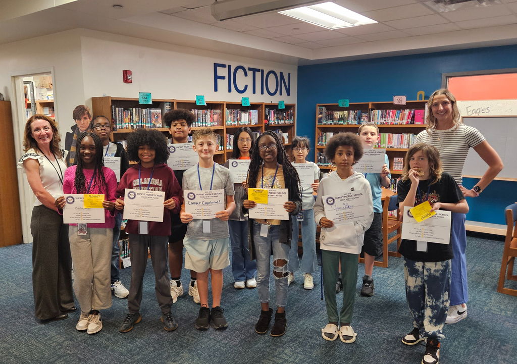 6th grade Eagles Nest recipients stand together smiling and holding their awards. 