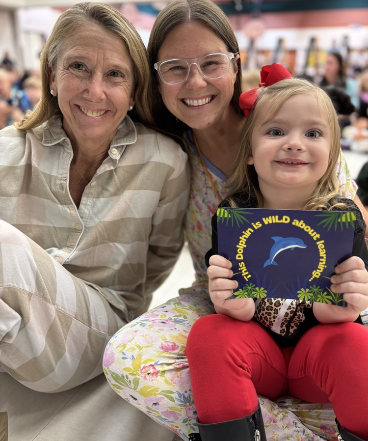 student with Mrs Cunningham and Mrs Sheila receiving a postcard 