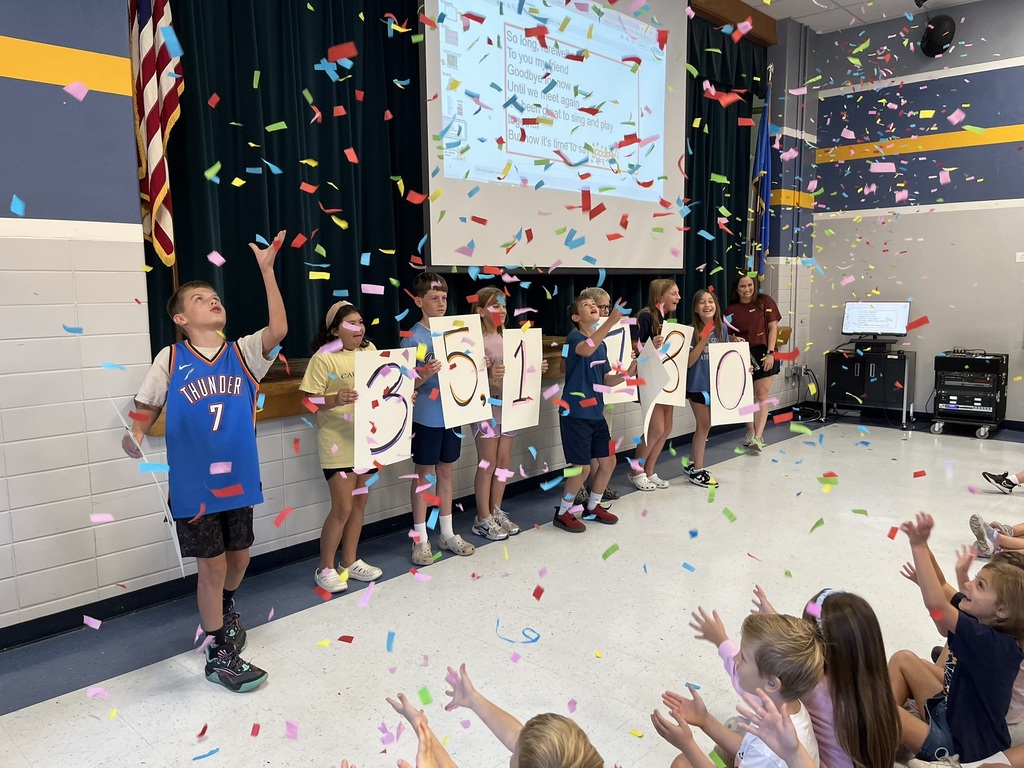 Students reveal fundraiser money earned amid confetti.