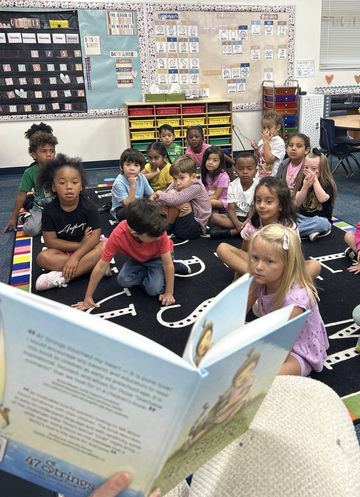 students listening to ms Hannah read a book 