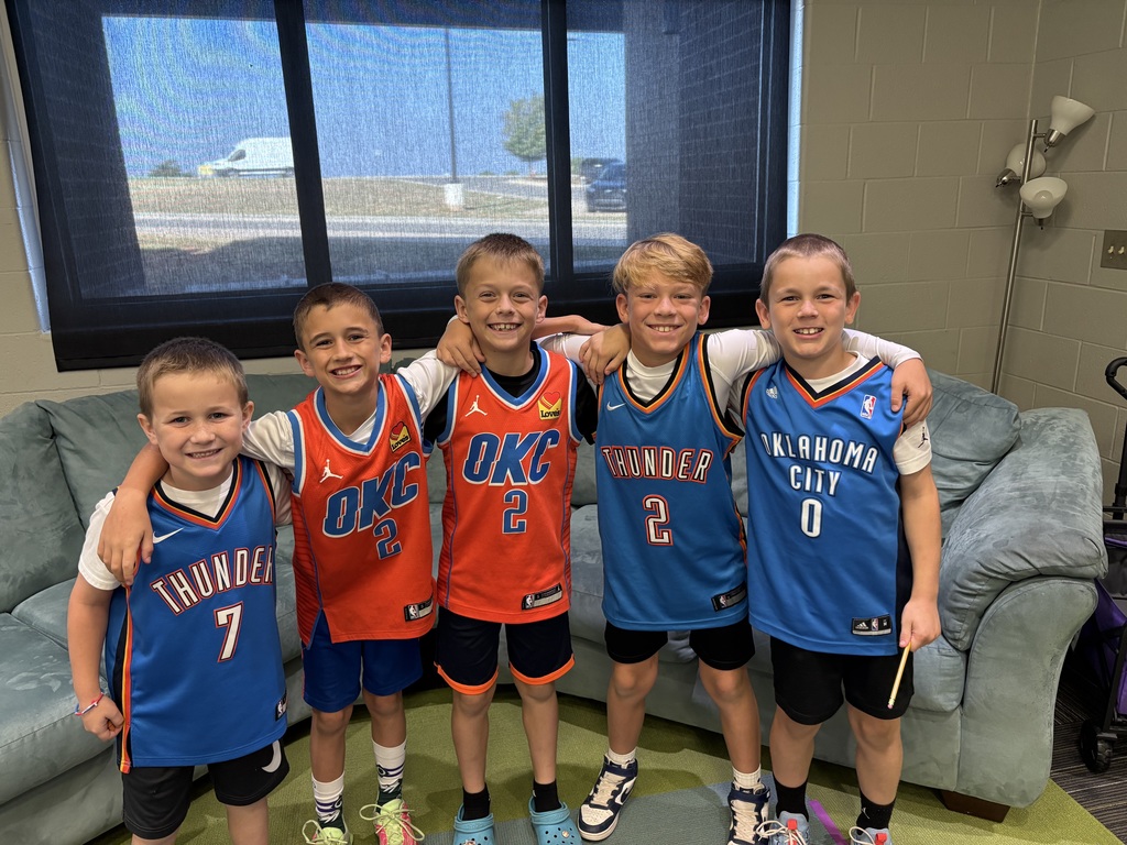 Group of boys smiling wearing matching outfits