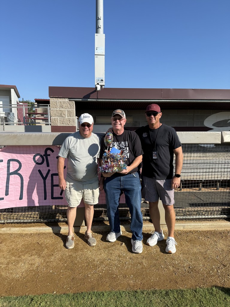 Marcus, Kyle Roberts  standing with teacher of the year sign 
