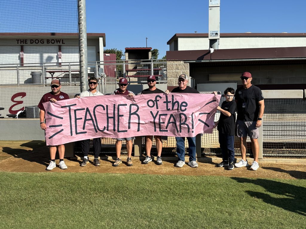 Marcus and Coaches standing with teacher of the year sign 