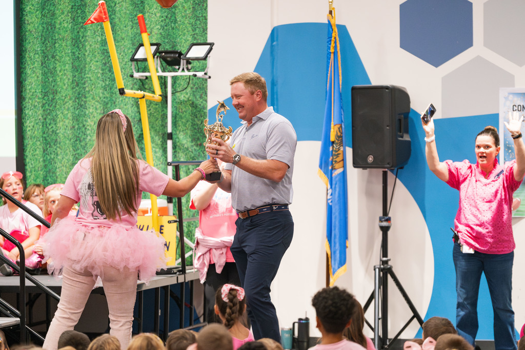 brandon weeden getting handed a trophy at an assembly