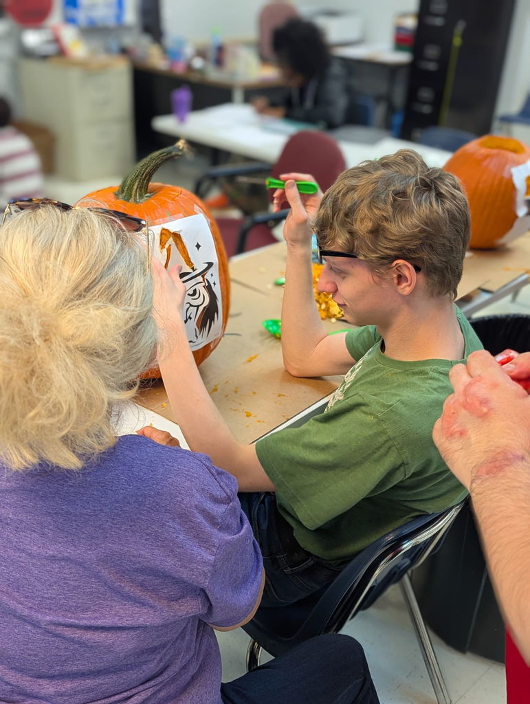 An intern carving a pumpkin
