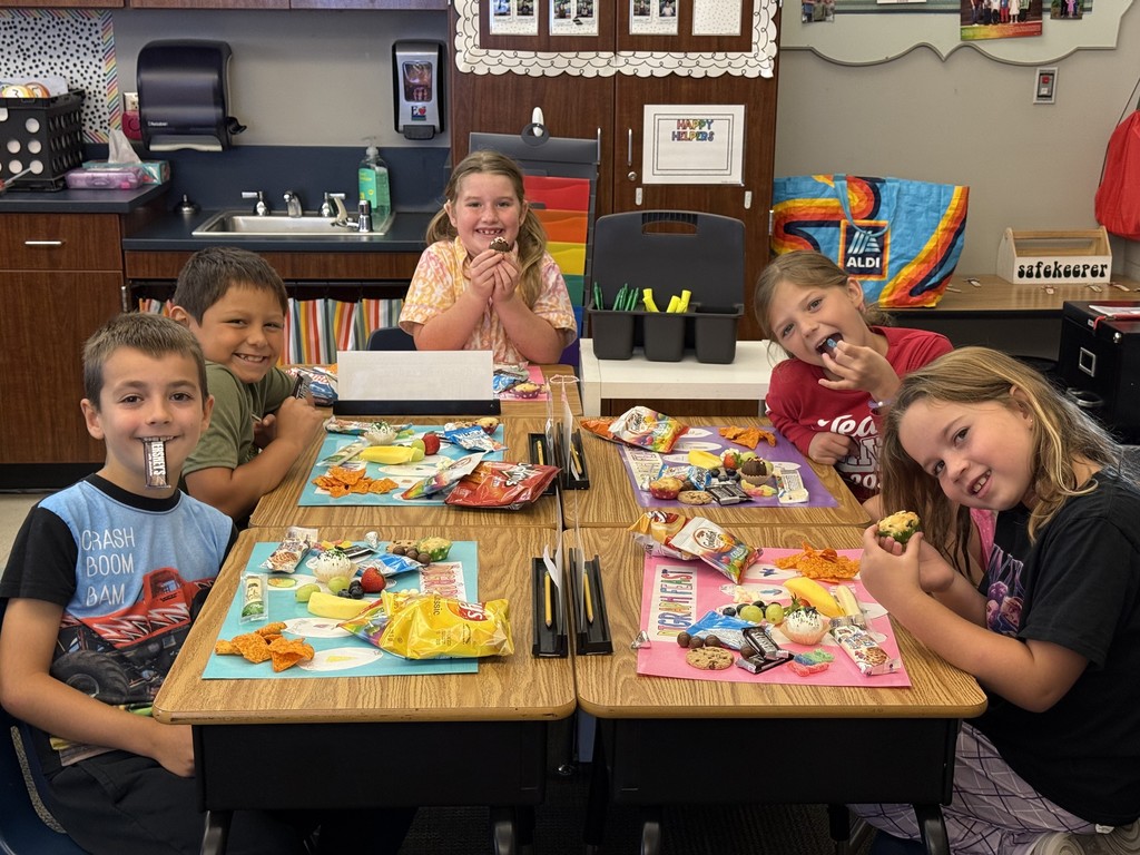5 students around desks with projects