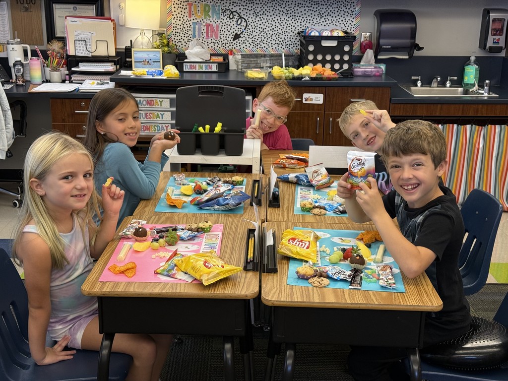 5 students around desks with projects