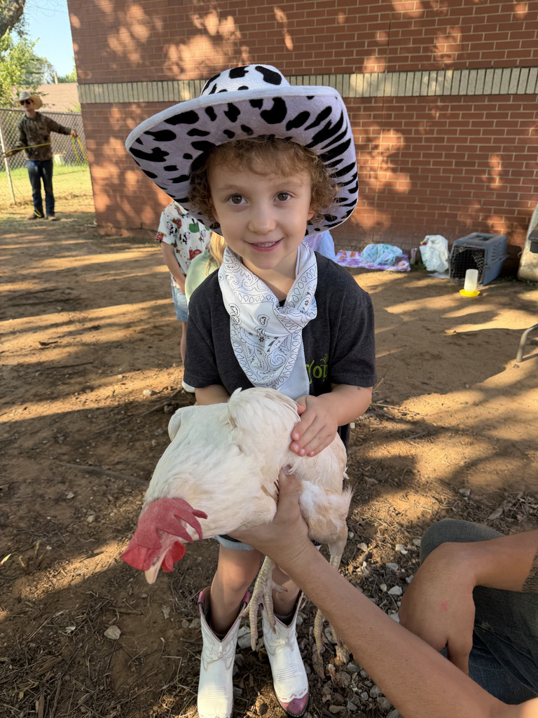 PreK student holds a chicken