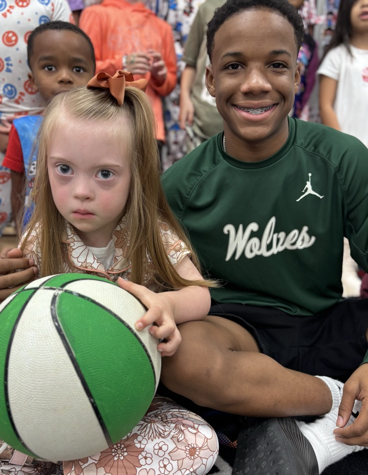 high school basketball player posing with a kindergartner 
