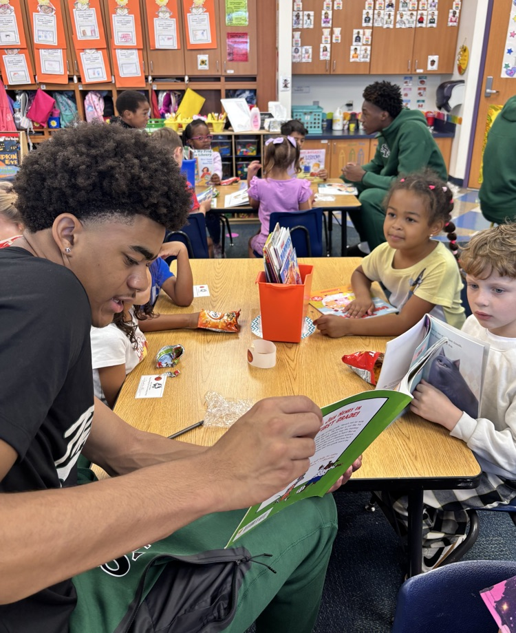 high school basketball player reading to kindergarten kids 