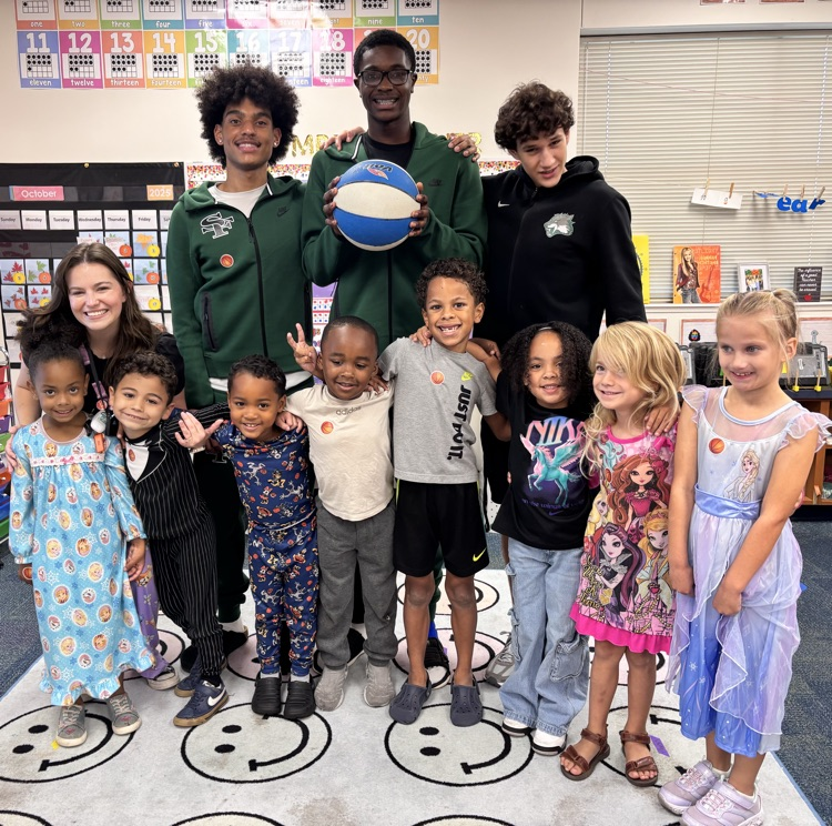 high school basketball players posing with kindergarten kids 