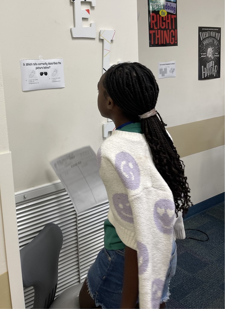 Student studies math problem on the wall as part of a review activity.