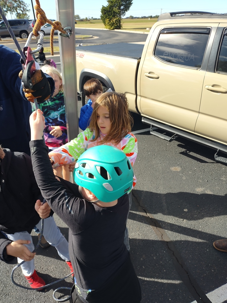 students lifting student in harness off ground