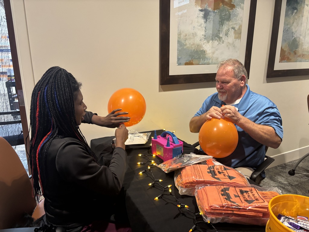 Intern and manager blow up balloons to decorate haunt the hospital