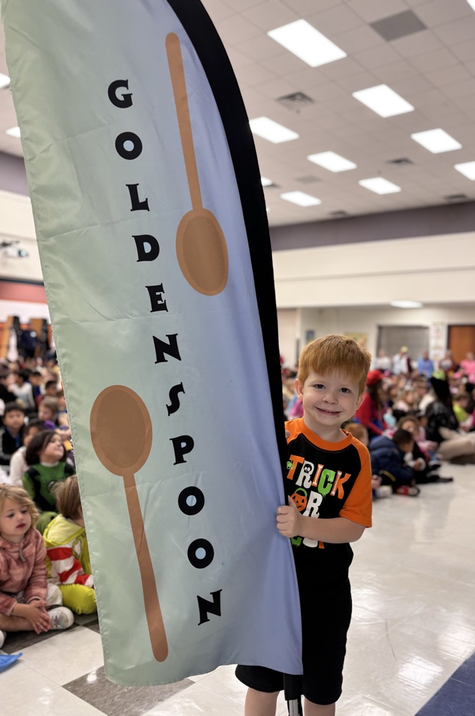 student holding golden spoon flag