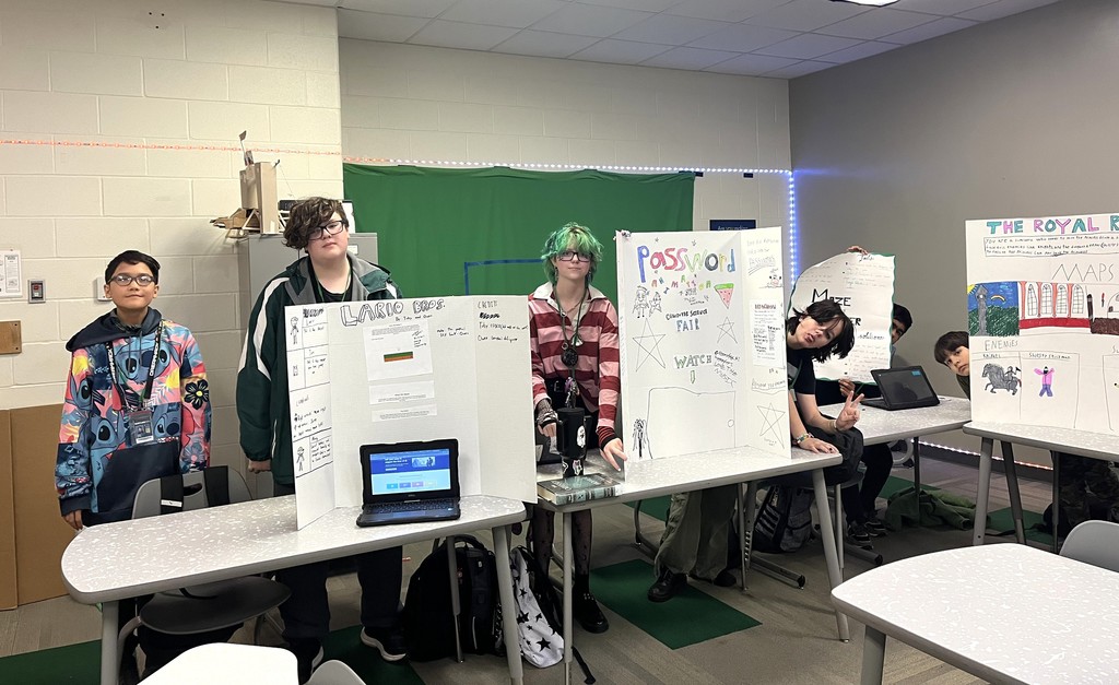 students standing next to their projects