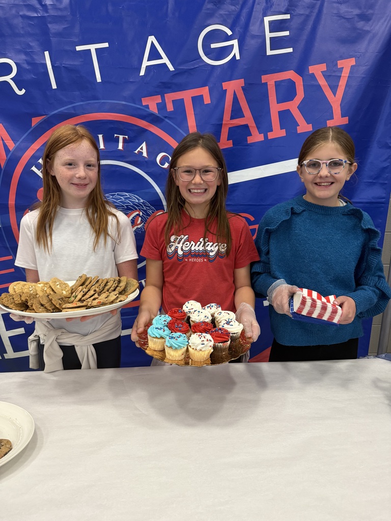 Students smiling next to cookies and cupcakes