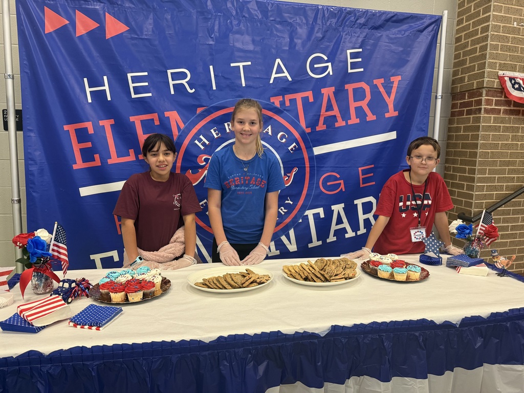 Three kids smiling at table with cookies