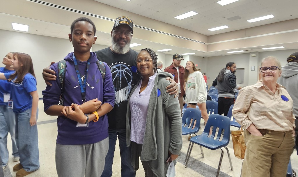 A teenager with two grandparents posing for a picture