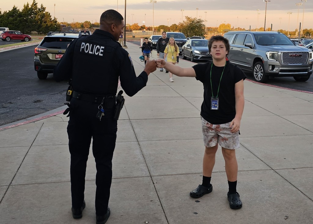 Officer Ross fist bumping a sleepy student when he first arrived to the school