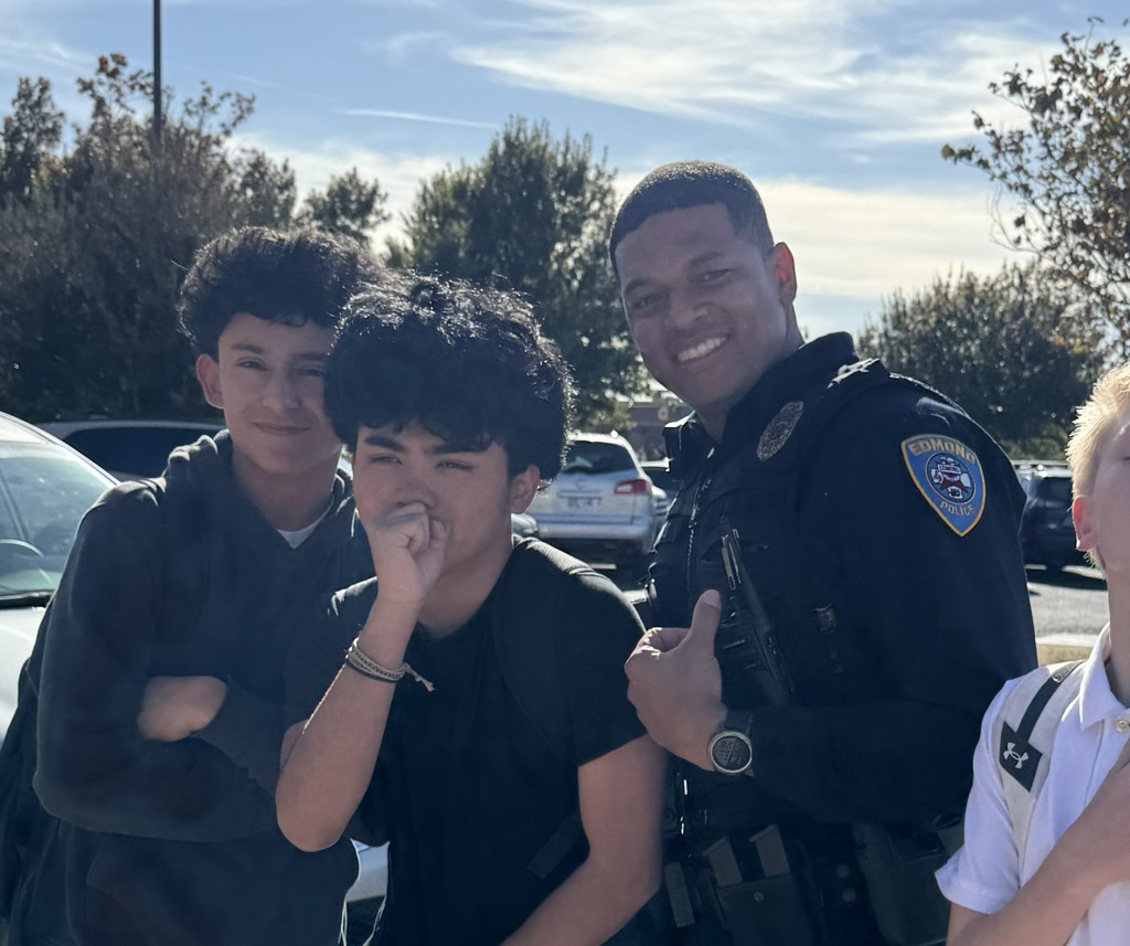 Officer Ross posing with 2 male students