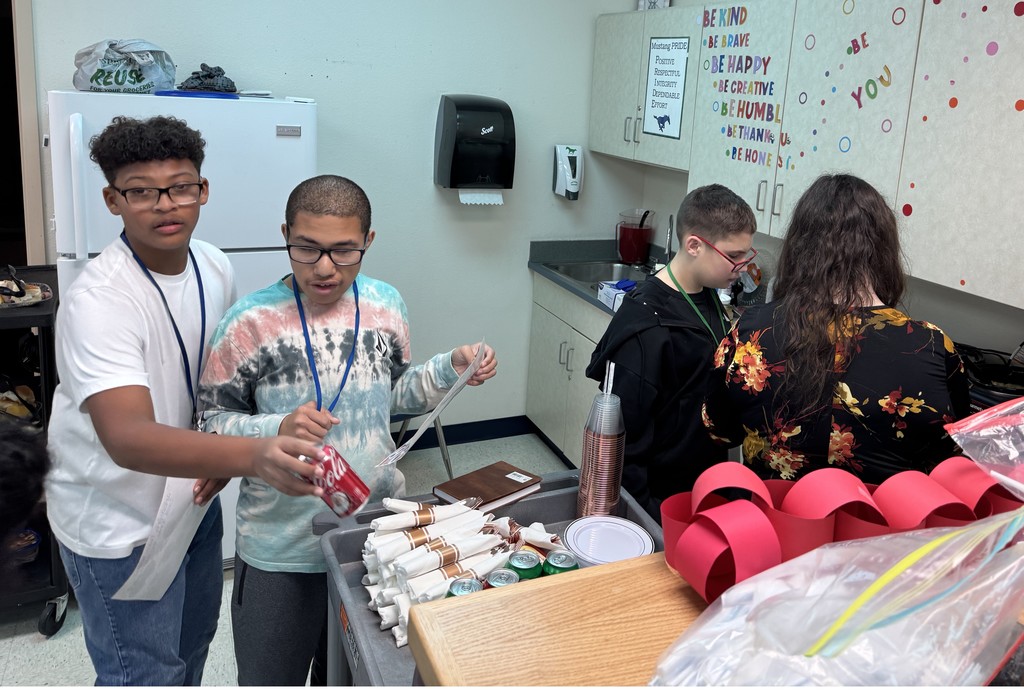 3 boys helping Mrs. Littlejohn prepare a plate for the guests