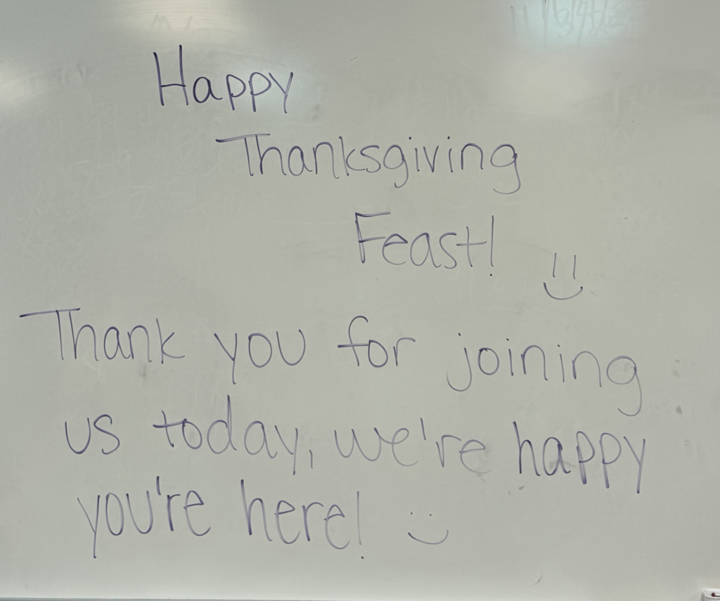 A sign that says, "Happy Thanksgiving Feast! Thank you for joining us today, we're happy you're here!"