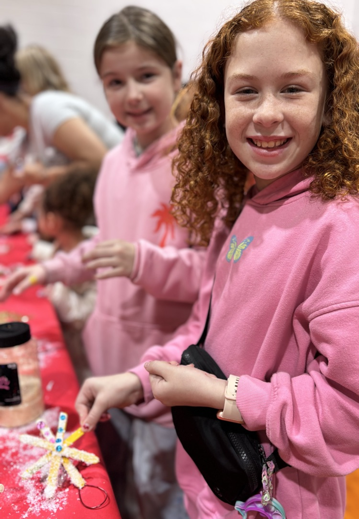 fifth grade girl decorating a snowflake ornament 
