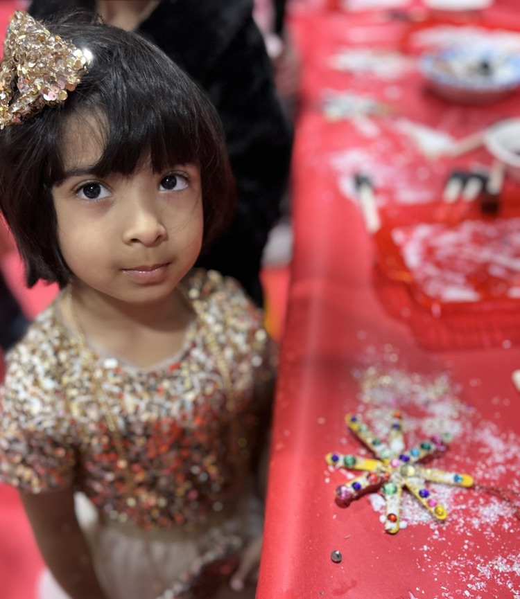 pre-k kid decorating a snowflake ornament 