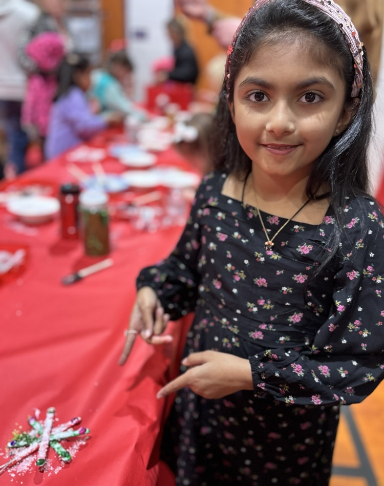 4th grade kid decorating a snowflake ornament 