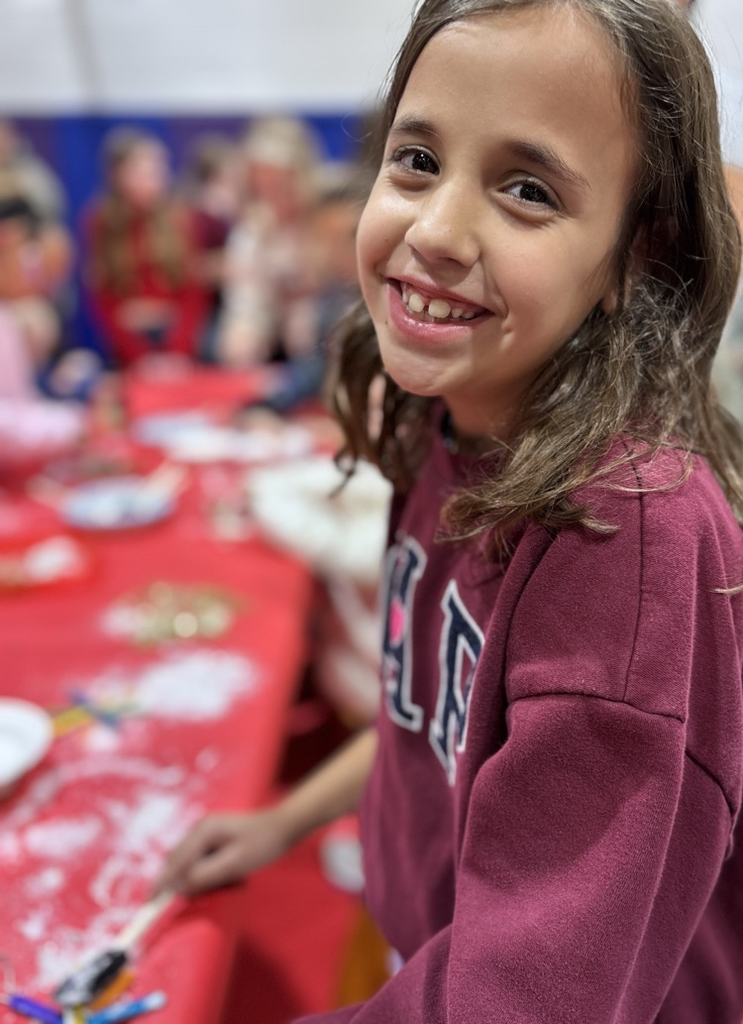 2nd grade kid decorating a snowflake ornament 