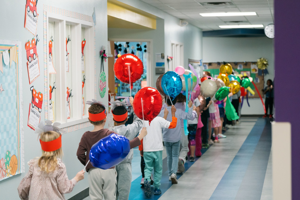 students walking with balloons down the hallways