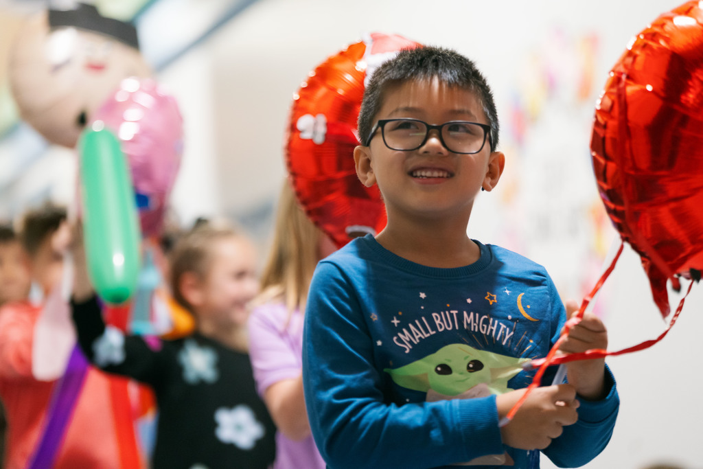 students walking with balloons down the hallways