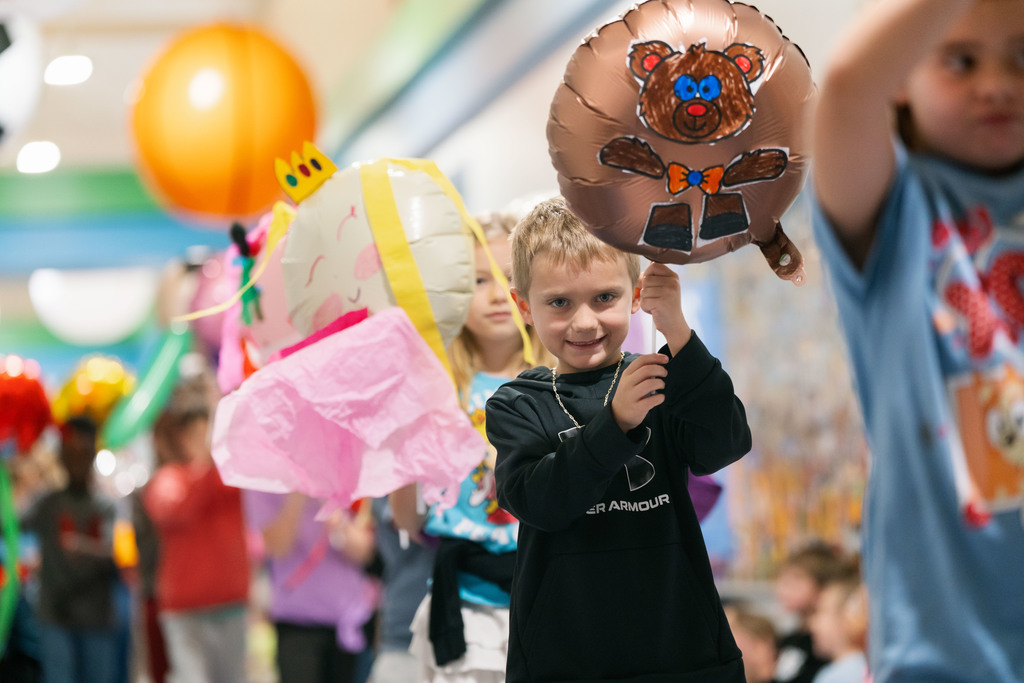 students walking with balloons down the hallways