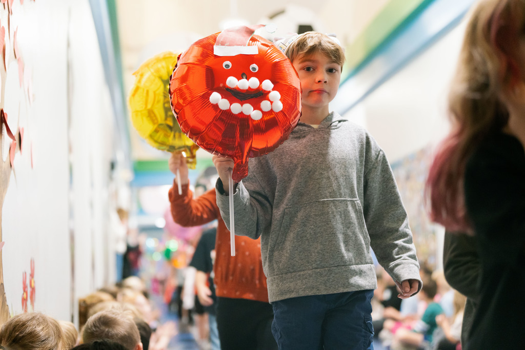 students walking with balloons down the hallways