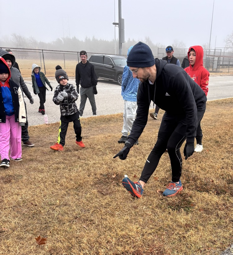 students and Mr Goodrich stretching at running club 
