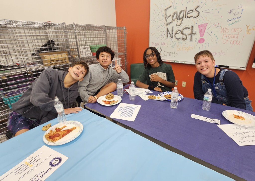 Students eating pizza together at Eagles Nest luncheon.