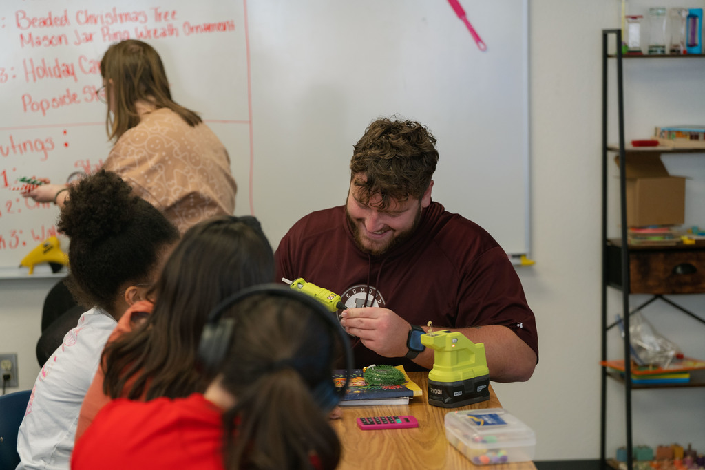 students making ornaments with the help of their teachers