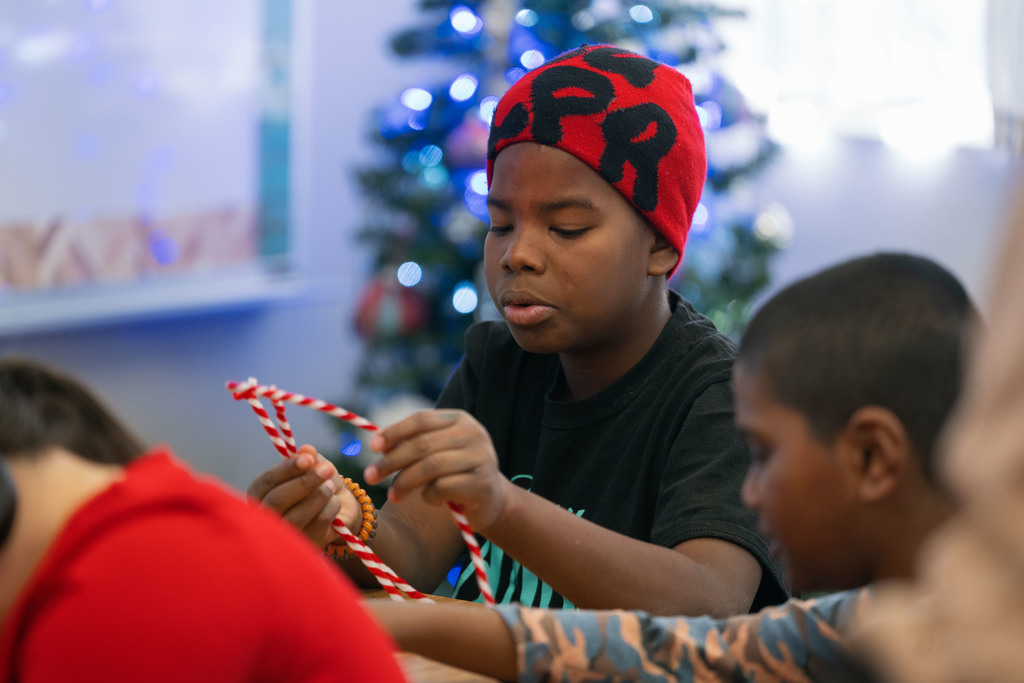 students making ornaments with the help of their teachers