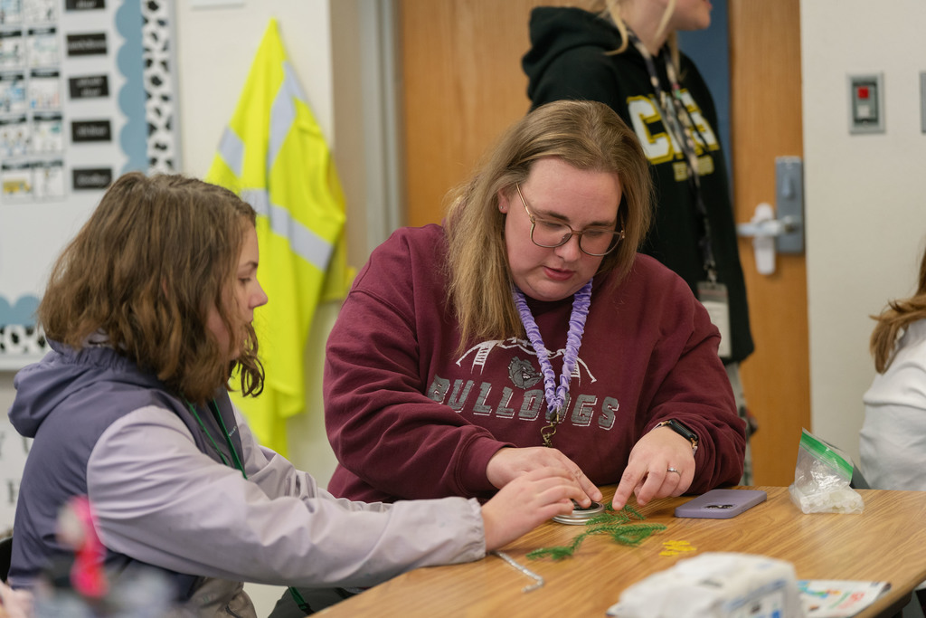 students making ornaments with the help of their teachers