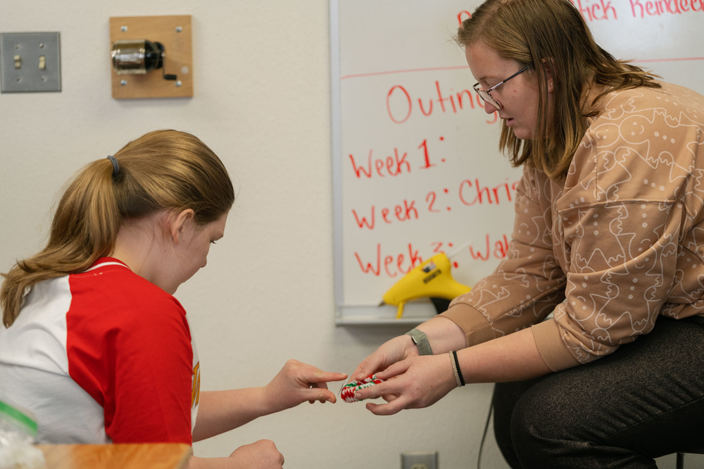 students making ornaments with the help of their teachers