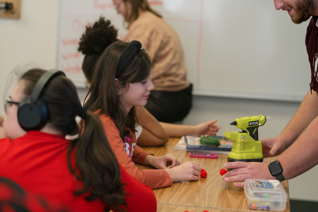 students making ornaments with the help of their teachers