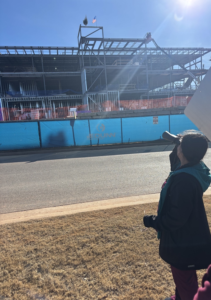 Intern using binoculars to see her signature!