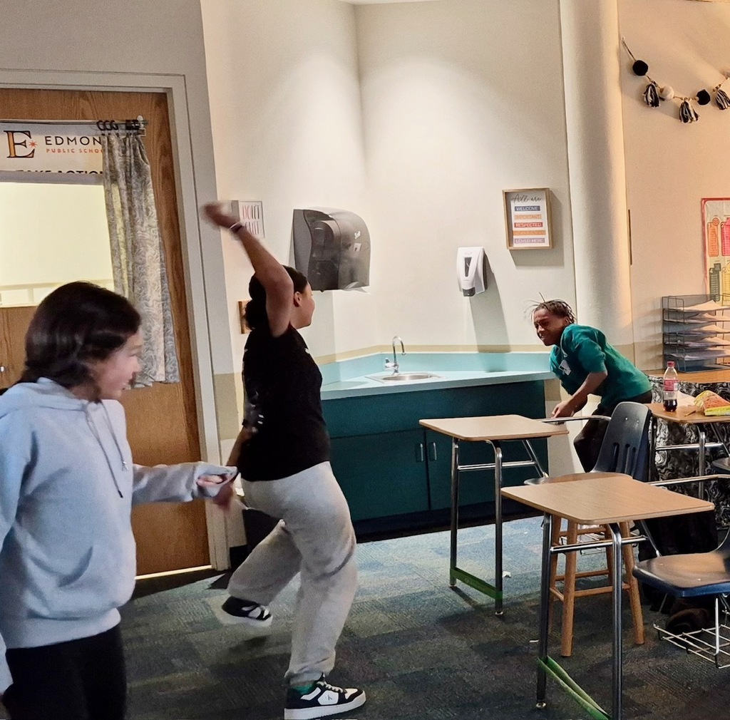 Student prepares to throw a paper "snowball" during a Math snowball fight review game.