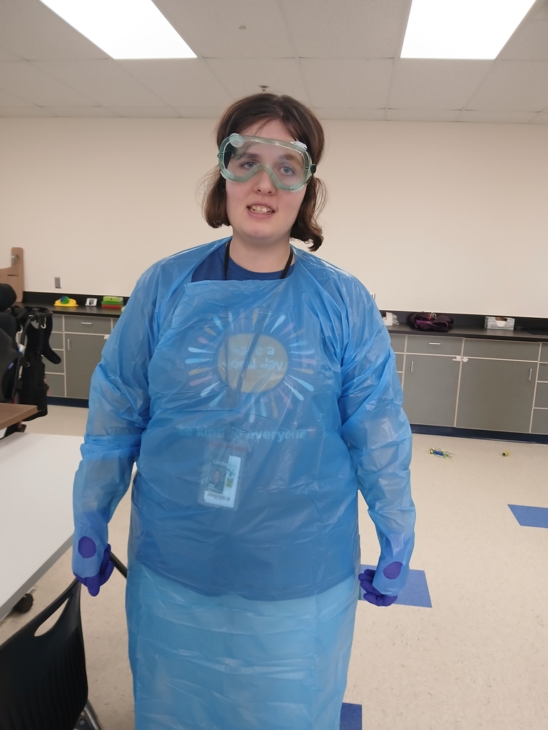 An intern showing some PPE she is wearing. 