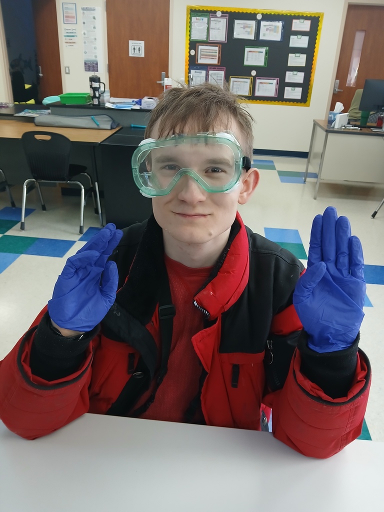 An intern displaying some PPE he is wearing. 