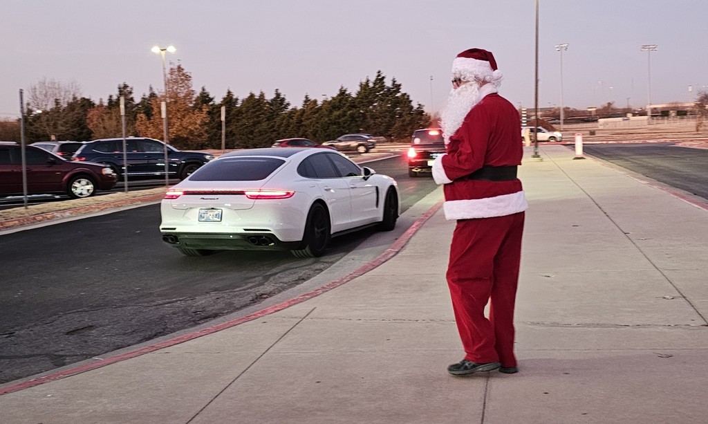 Santa watching the cars as they pull up to school to drop off students