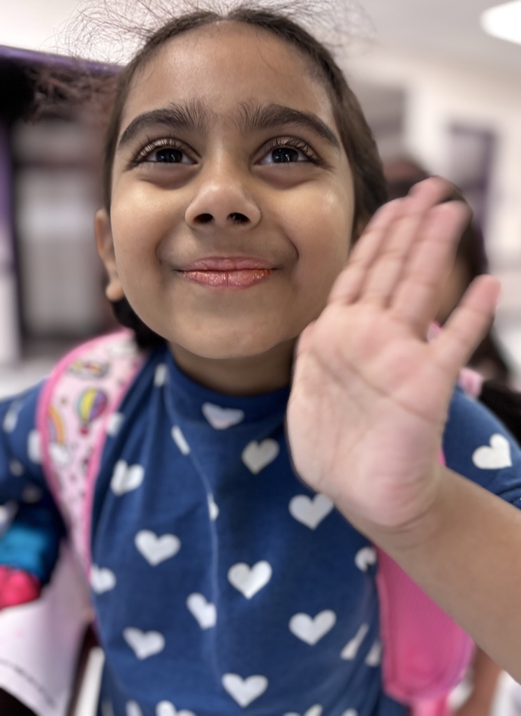 student waving at camera 