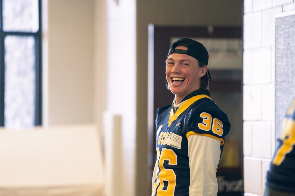 football players talking to elementary students