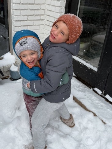students hugging in the snow